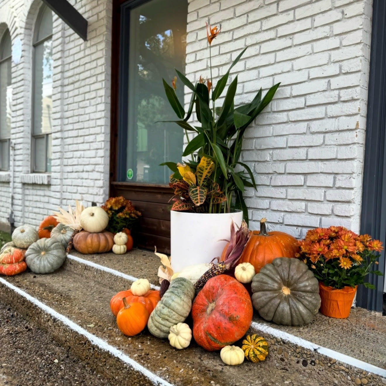 Funkytown Pumpkins fall porch display with pumpkins, mums, and seasonal decor